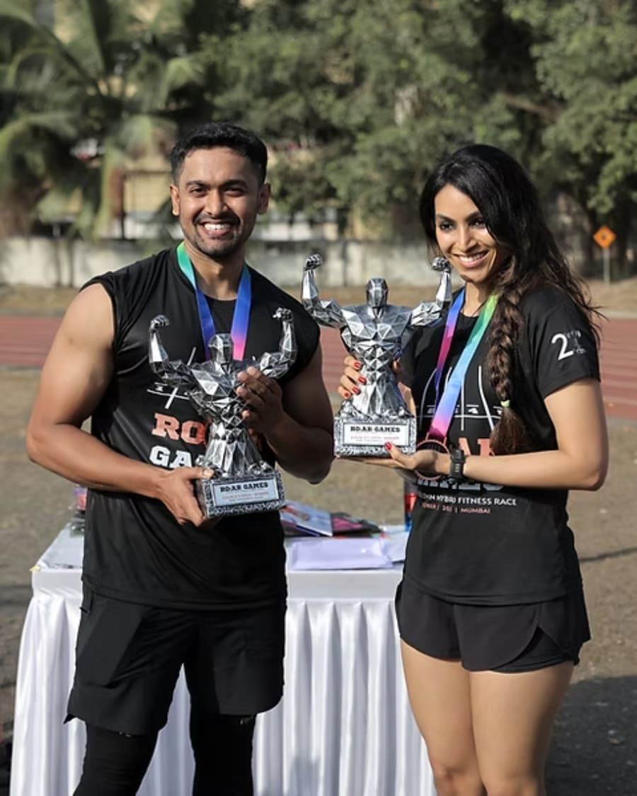 Two athletes holding their R.O.A.R Games trophies