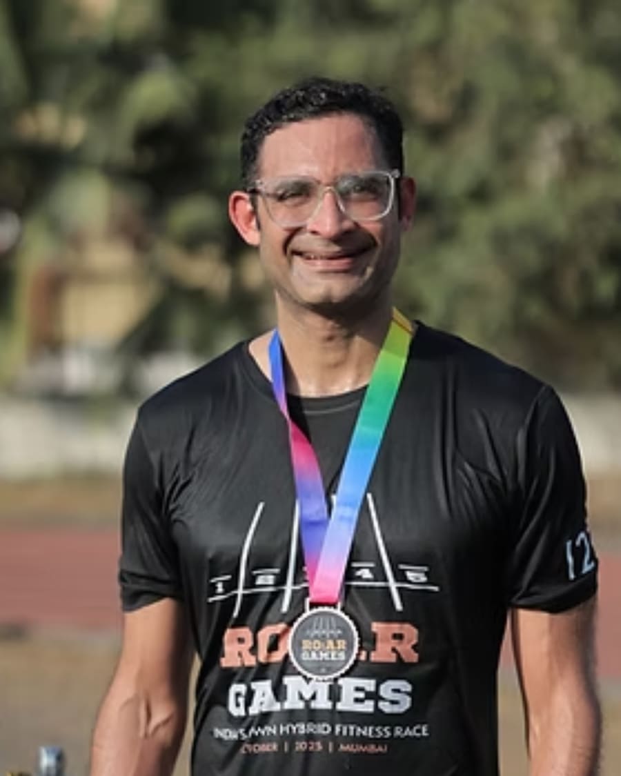 A finisher smiling in his R.O.A.R Games medal