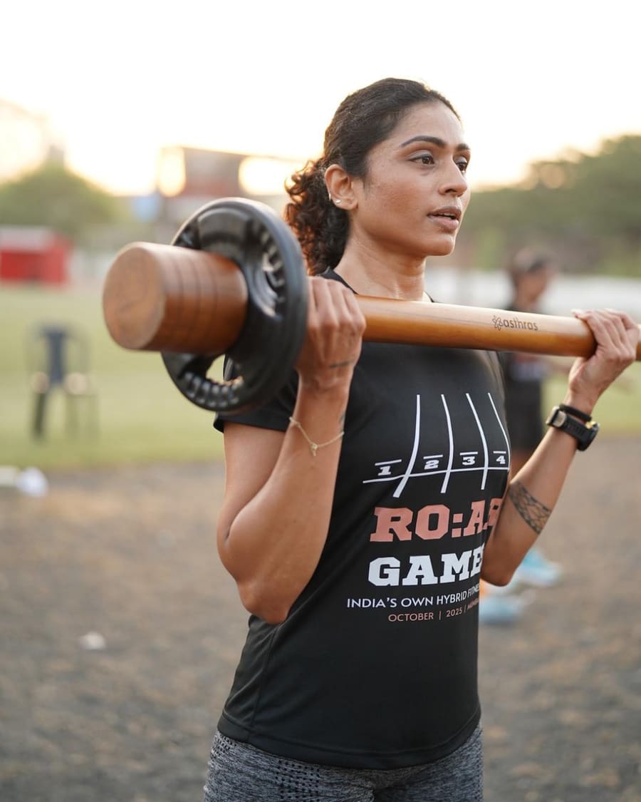 An athlete carrying the R.O.A.R mace on her shoulder