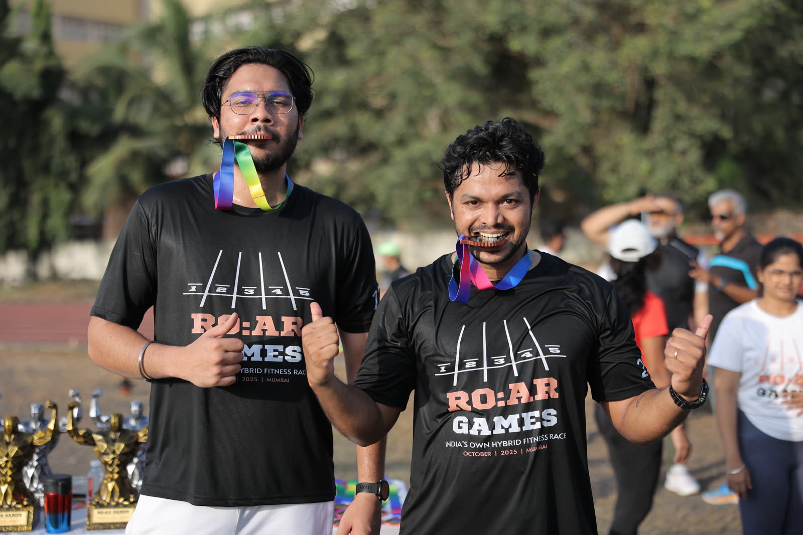Two finishers playfully biting their medals
