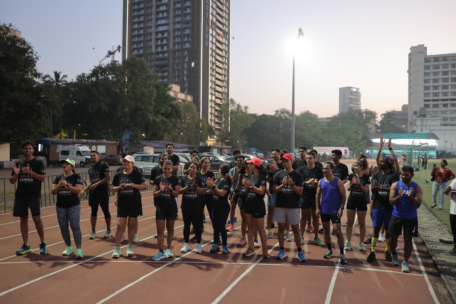 Athletes gathered in a circle on the track at night