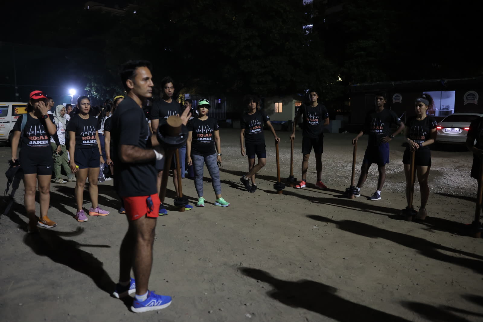 Athletes lined up with maces at dusk