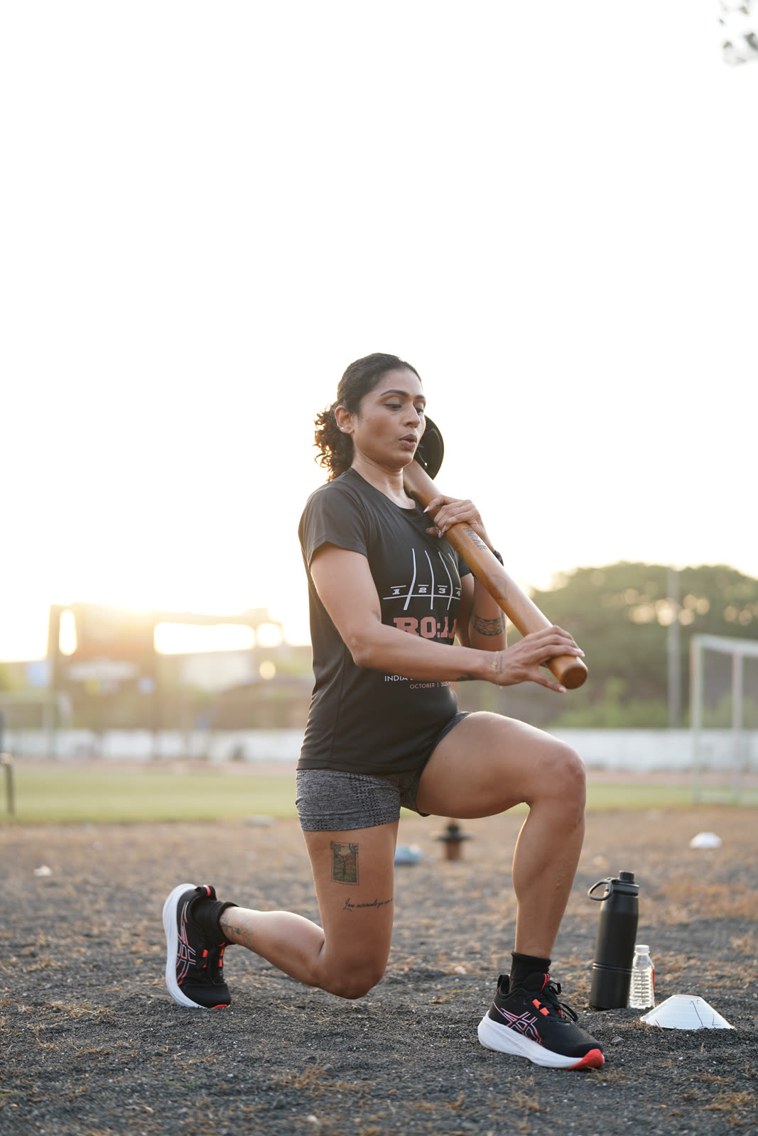 An athlete performing a lunge with the R.O.A.R mace at sunset