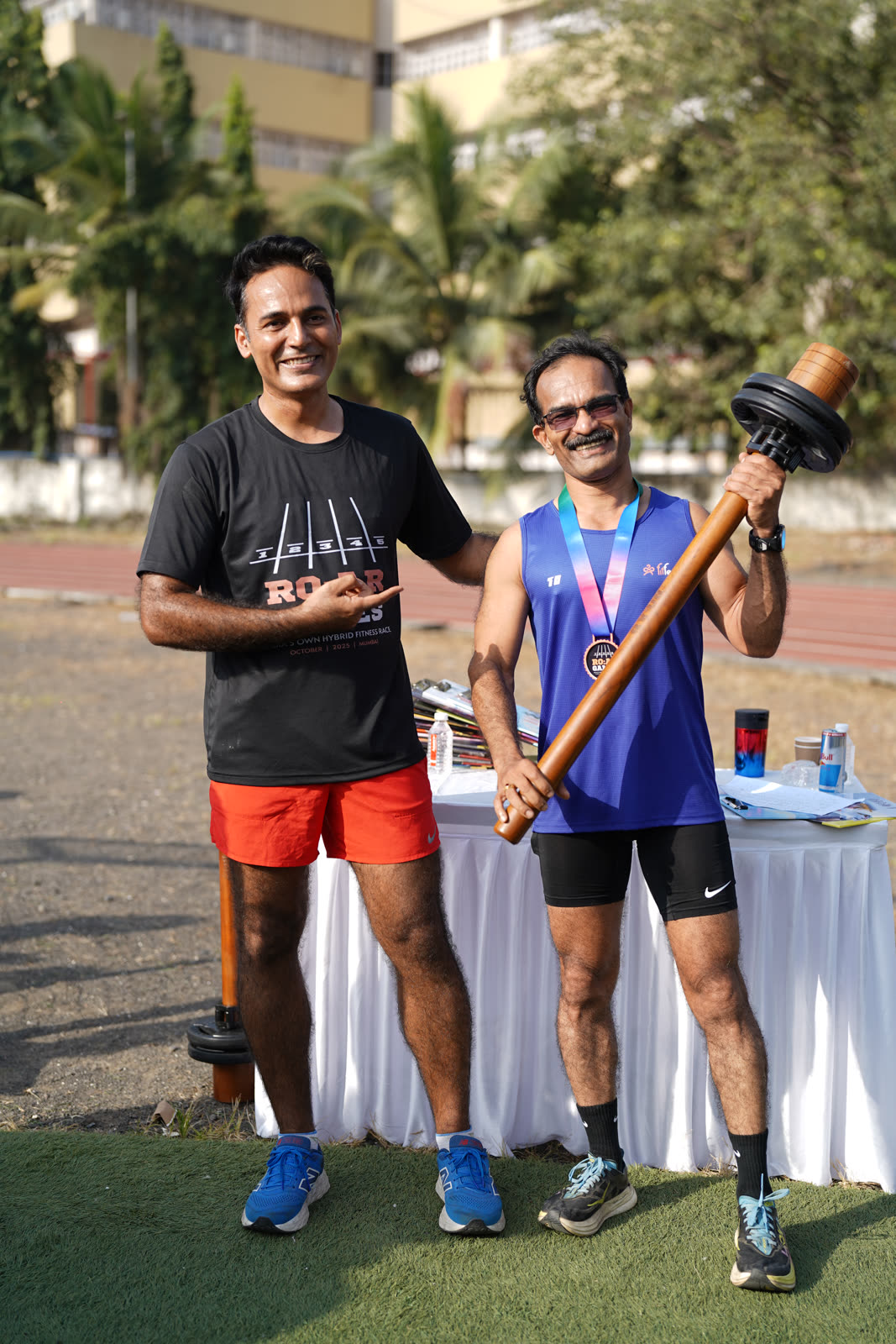 Two athletes posing with the mace trophy