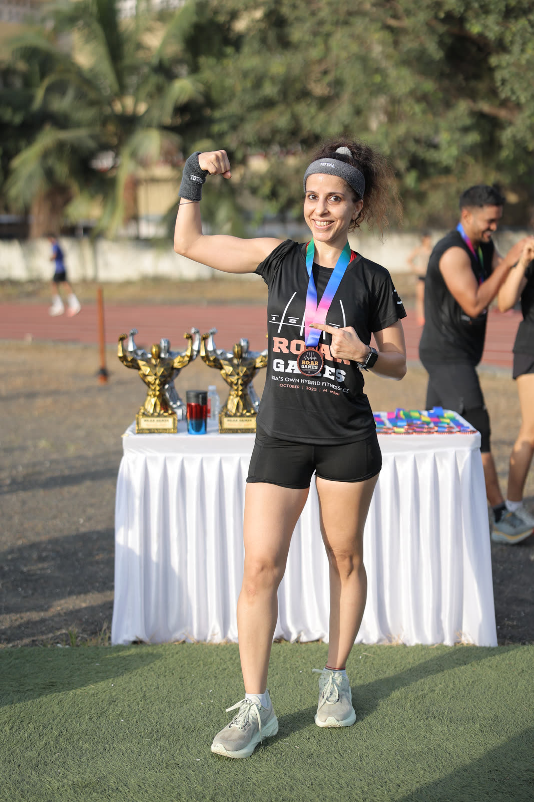 A finisher flexing with her R.O.A.R Games medal