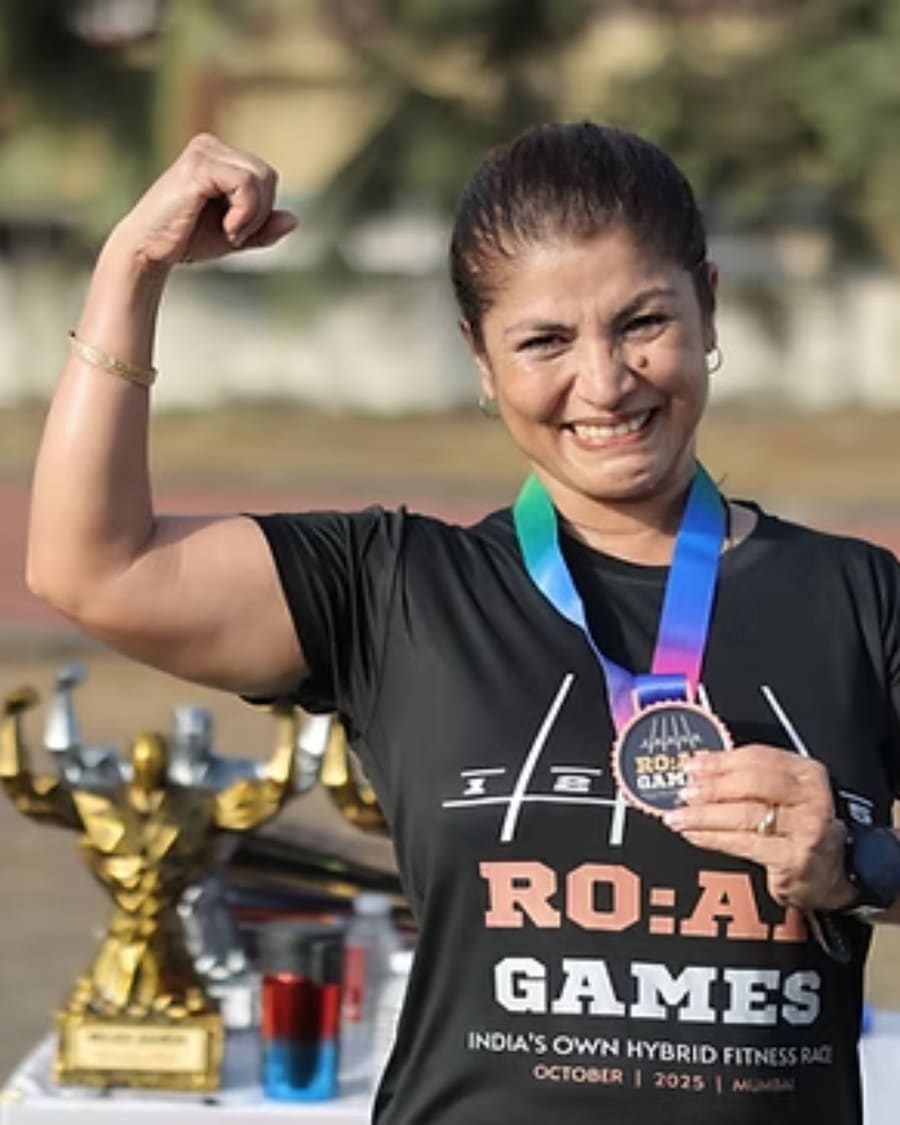 A winner pointing at her R.O.A.R Games medal